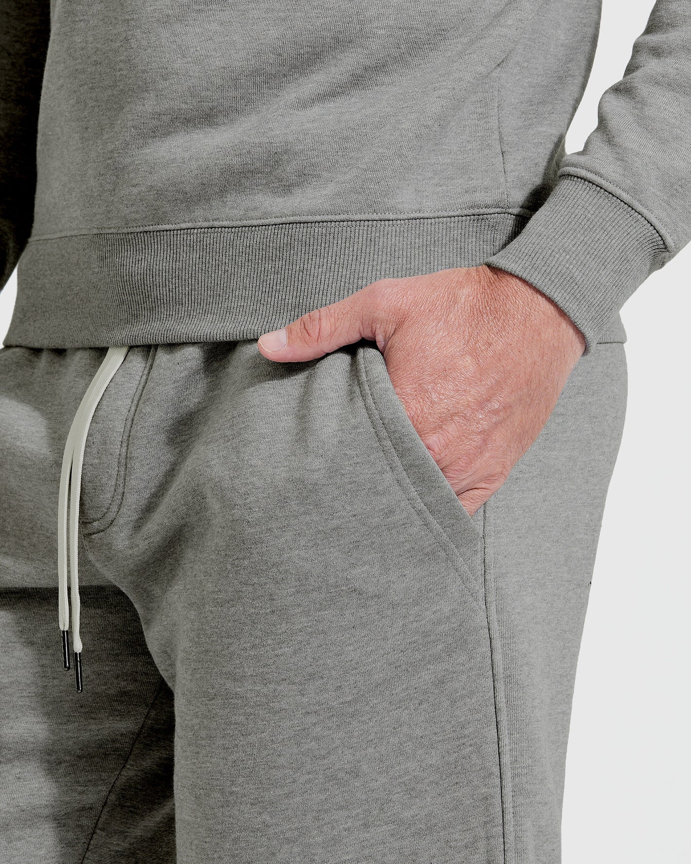 Wearing Medium Heather Gray Fleece French Terry Shorts with pocket details.