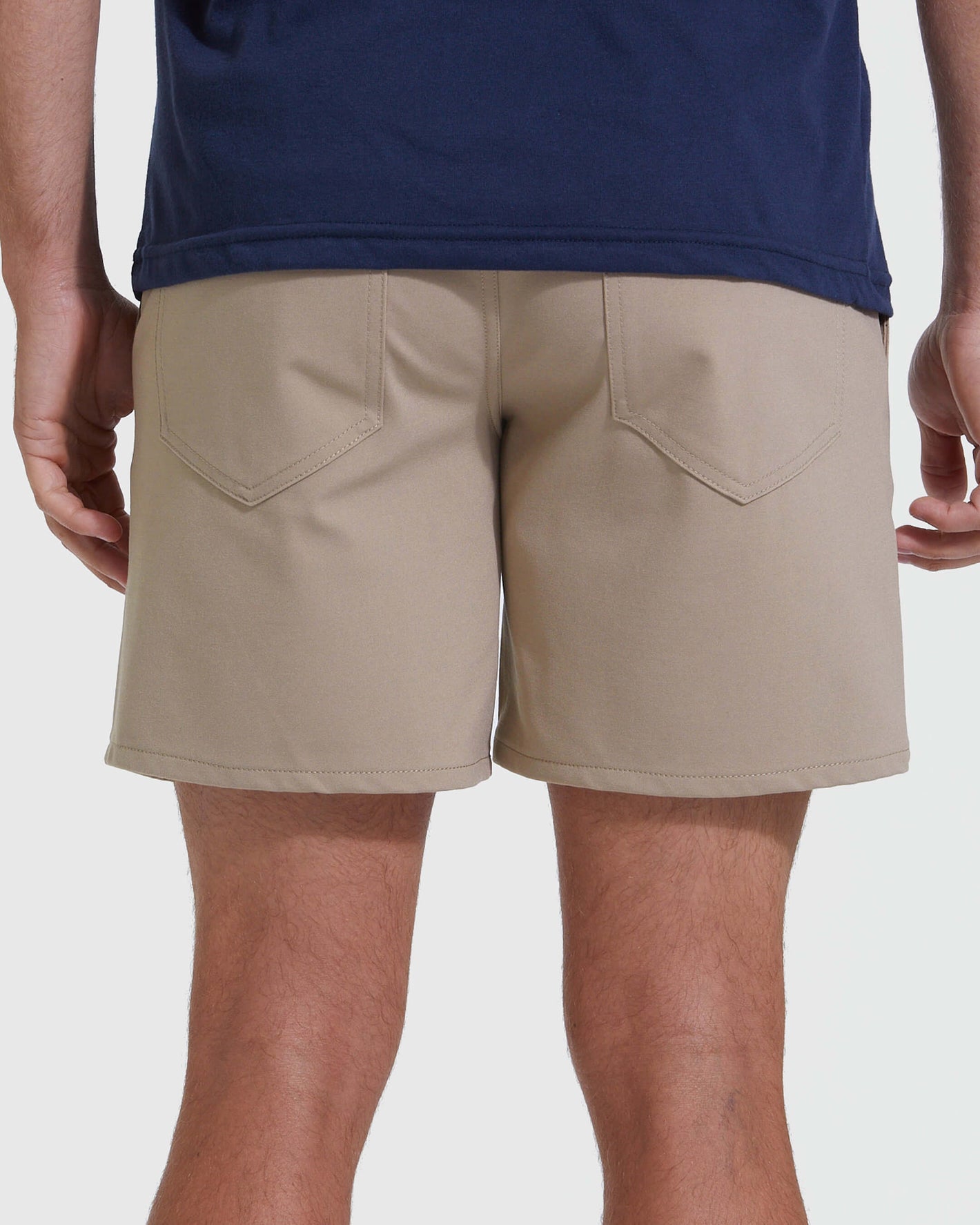 Khaki Commuter Short: light khaki shorts with back pockets, worn casually.