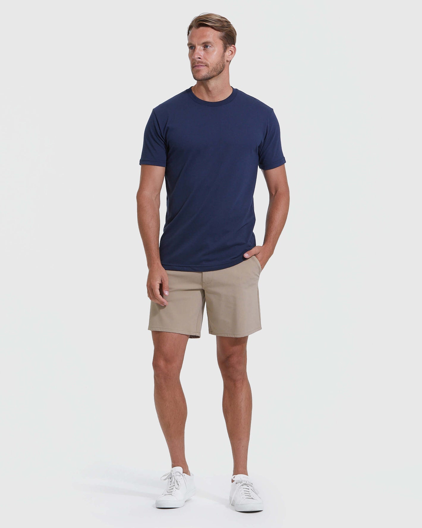 Man wearing Khaki Commuter Short with navy T-shirt and white sneakers.