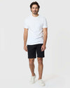 Man wearing 9 Black Classic Twill Shorts, white tee, sneakers.
