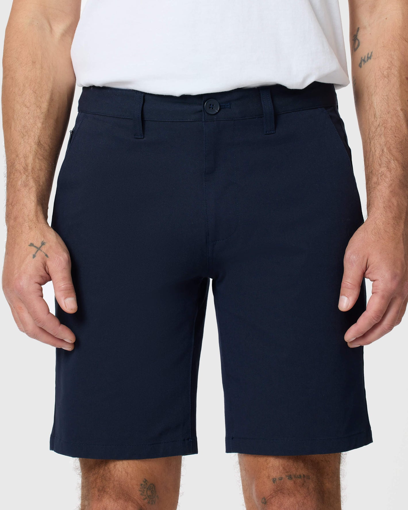 Person wearing Navy Twill Short with white T-shirt, tattoos visible.
