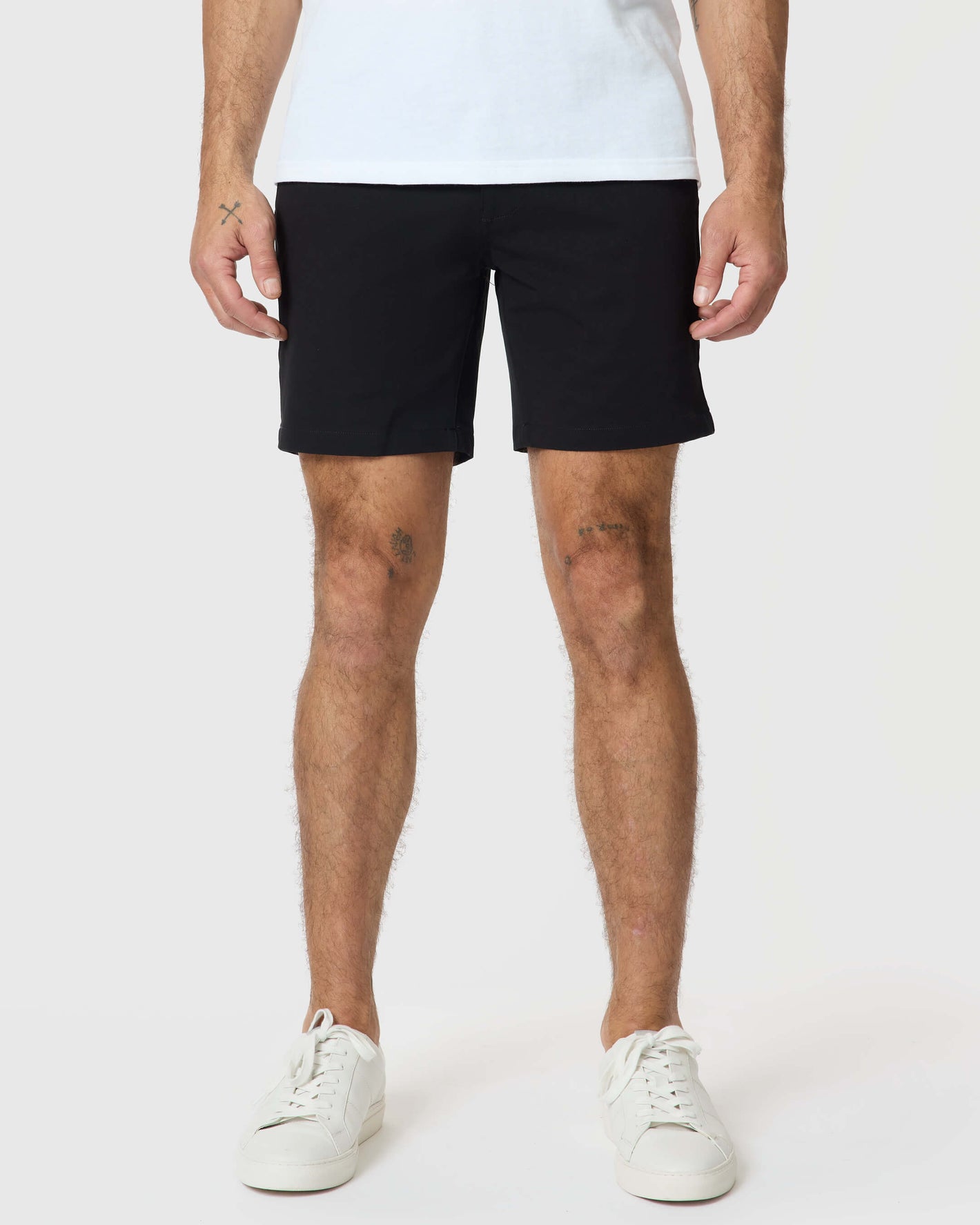 7 Black Classic Twill Shorts on model with tattoos, white sneakers.