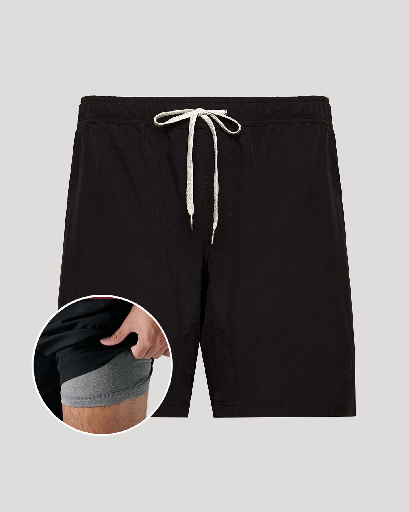 Black shorts with a drawstring on a gray background, showing a close-up of the waistband.