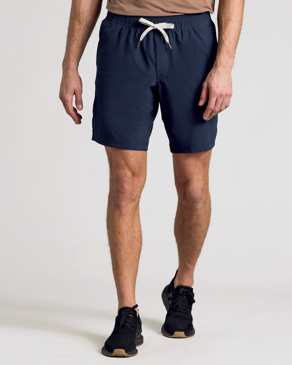 Man wearing Navy 9 Active Quick Dry Shorts with black sneakers.
