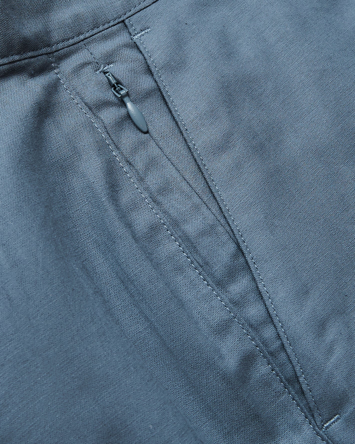Close-up of 9 Navy & Fiord Linen Shorts' concealed zipper pocket detail.