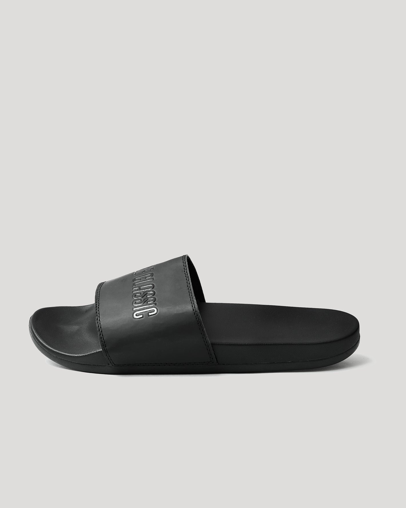 Black Comfort Slides with wide embossed strap, contoured footbed, and lightweight sole.
