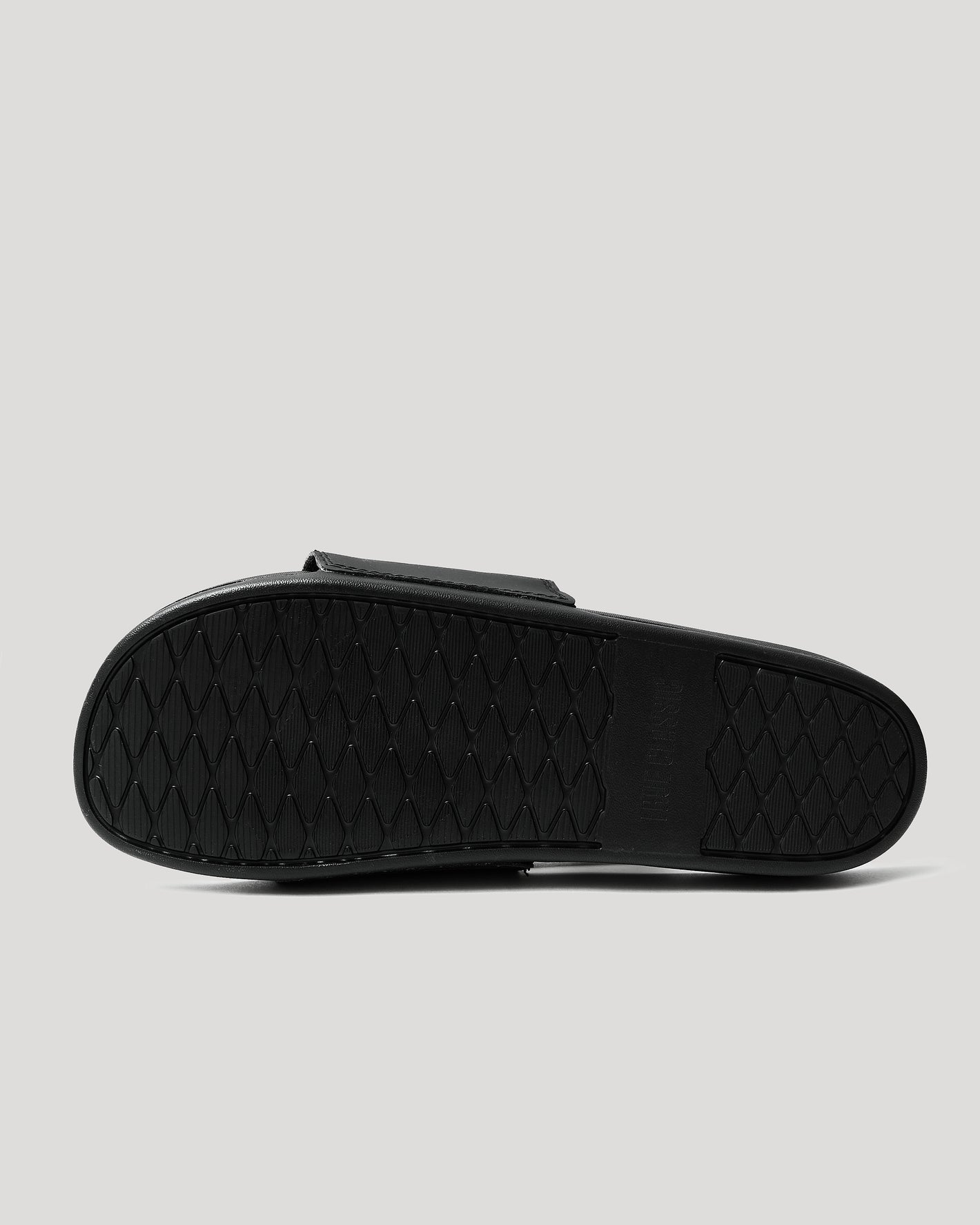 Black Comfort Slides' outsole with textured rubber tread pattern for grip.