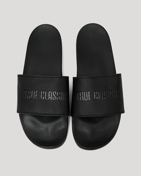 Black Comfort Slides with TRUE CLASSIC embossed strap, side by side.