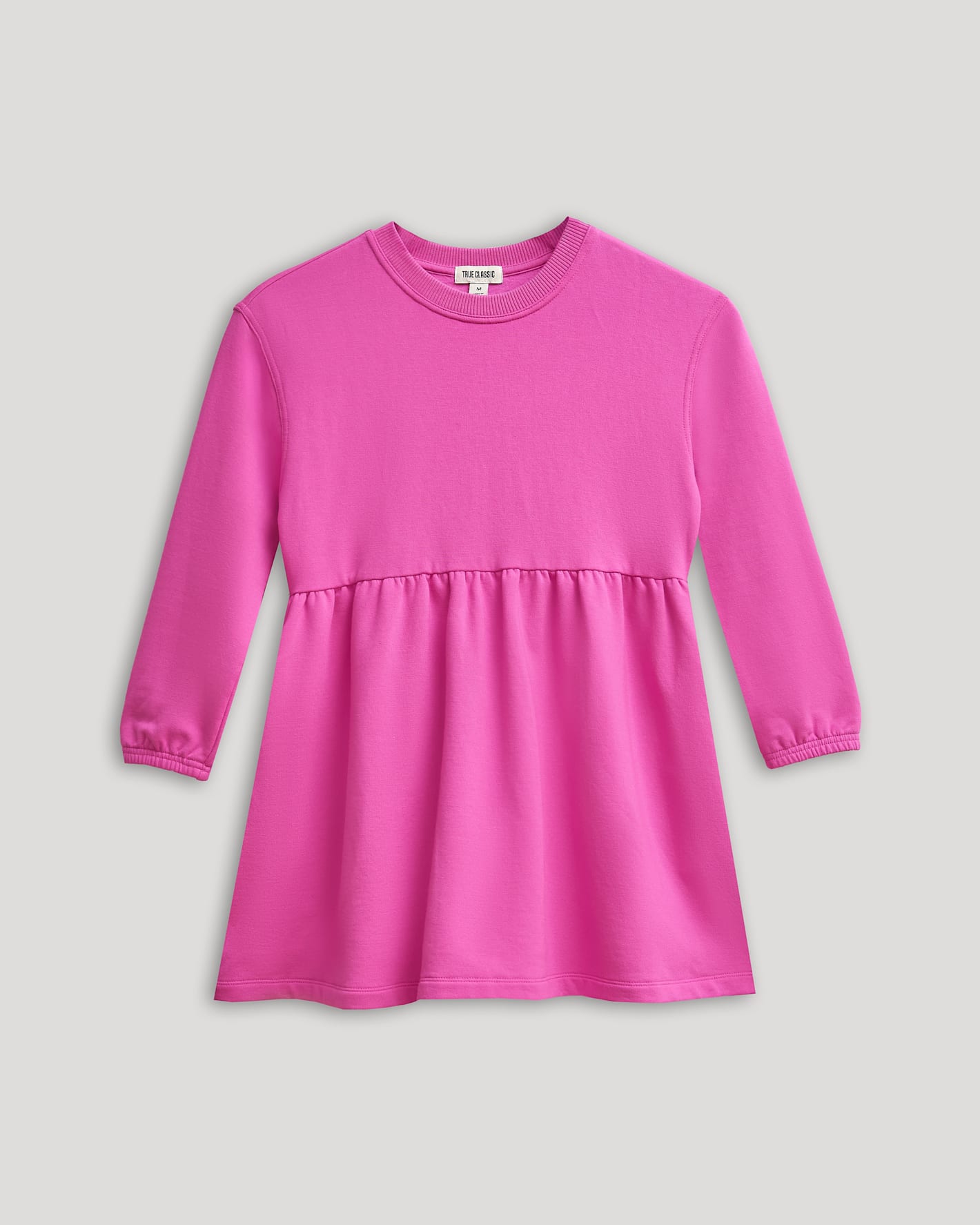 Girls Electric Fuchsia Long Sleeve Fleece Dress with peplum waist and elastic cuffs.