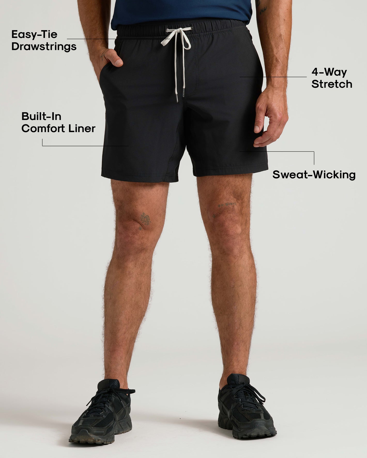 Person wearing black shorts with text highlighting features on a white background