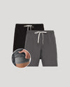 Two pairs of shorts, one black and one gray, with drawstrings on a light gray background.