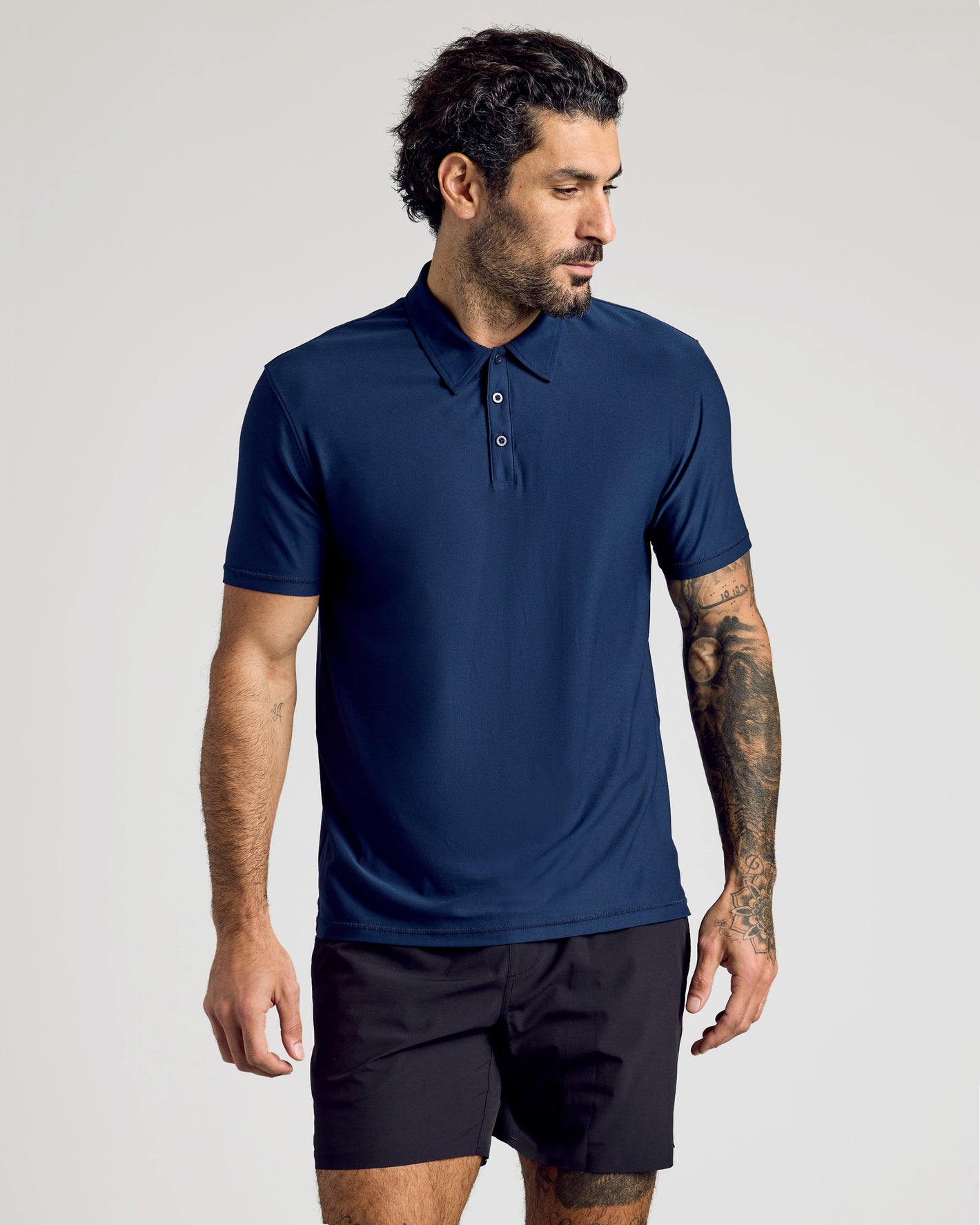 Man wearing Active Polo 10-Pack navy shirt with tattoos visible.