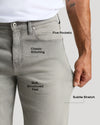 Gray jeans with text labels on features like 'Five Pockets', 'Classic Stitching', 'Soft Structured Feel', and 'Subtle Stretch'.