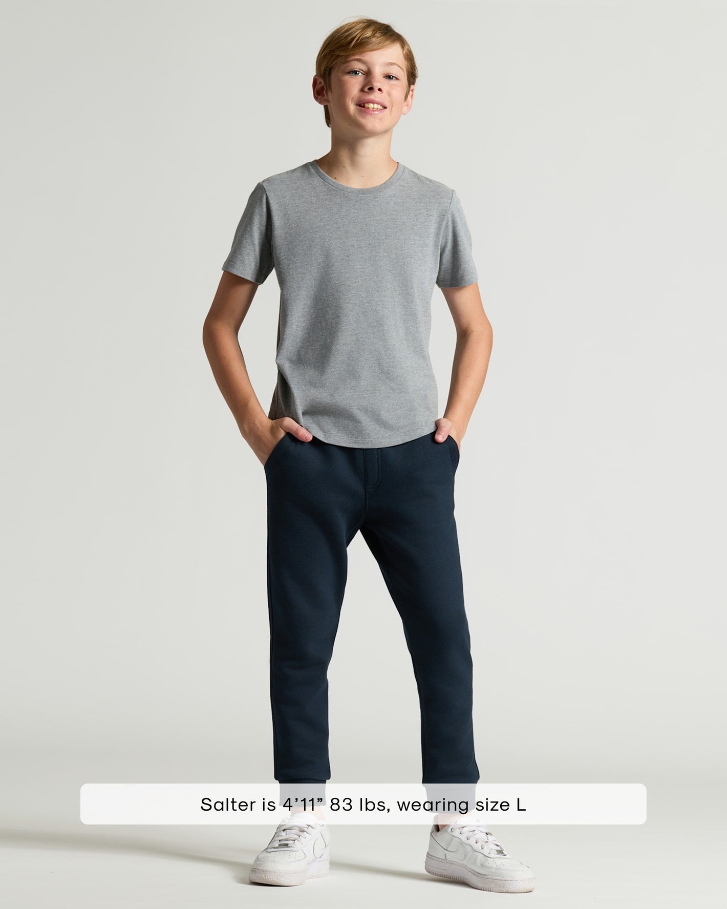 Boy modeling Boys' Classic Curved Hem Crew Neck, grey T-shirt, navy joggers.