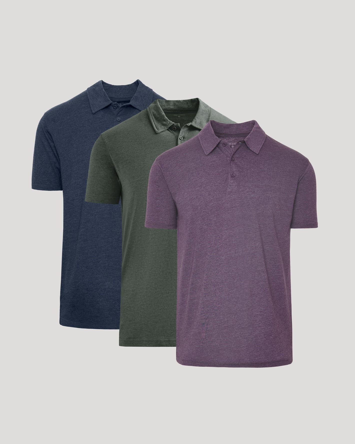 Three polo shirts in blue, green, and purple on a light gray background