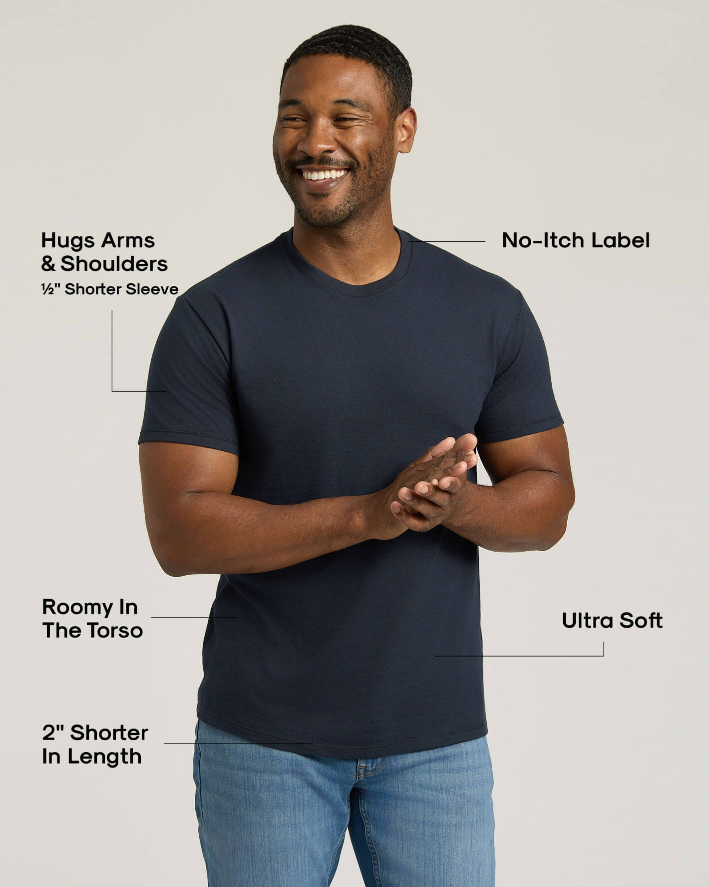 Man wearing a navy blue t-shirt with text highlighting features on a light gray background
