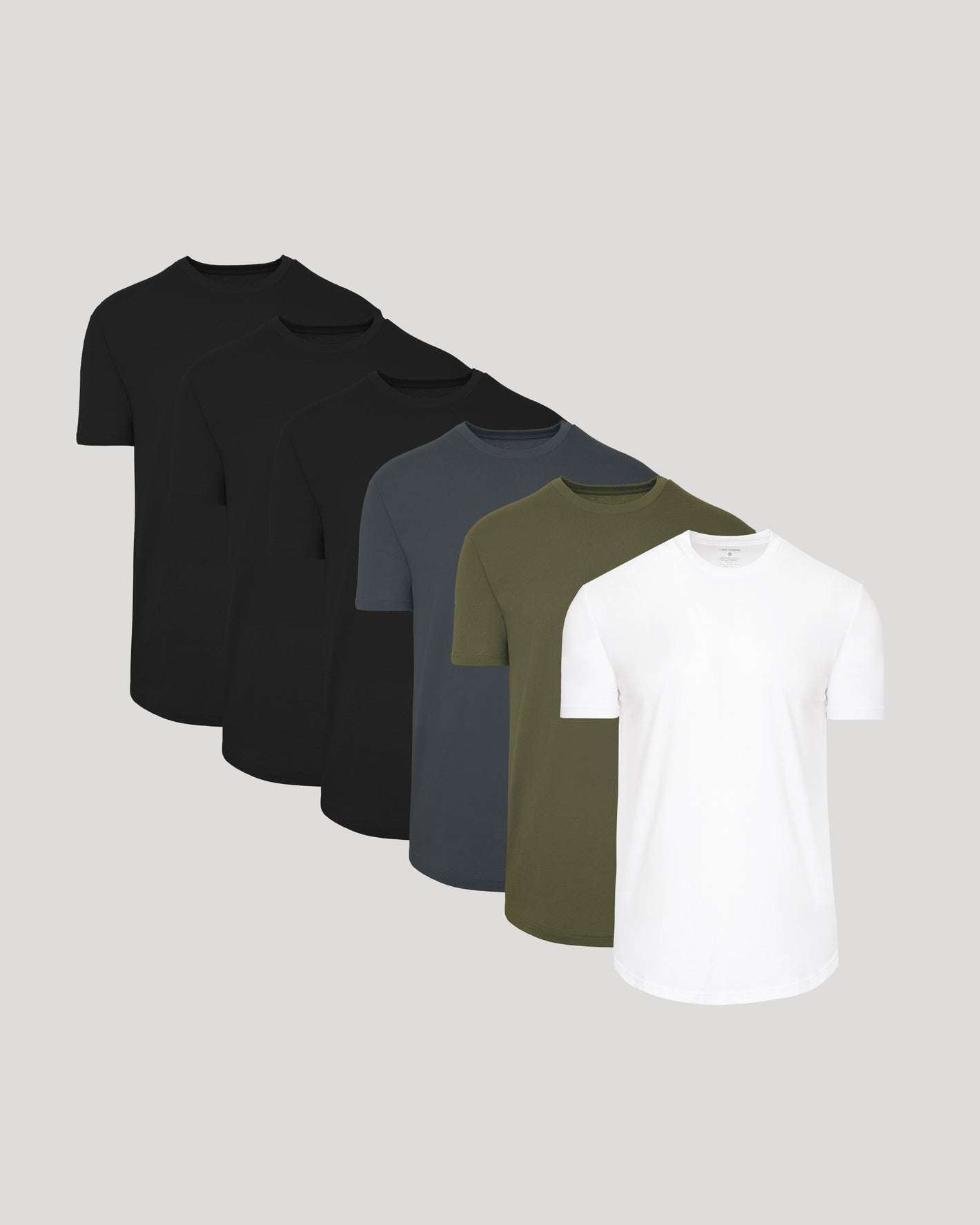 Five plain t-shirts in black, gray, green, and white on a light gray background