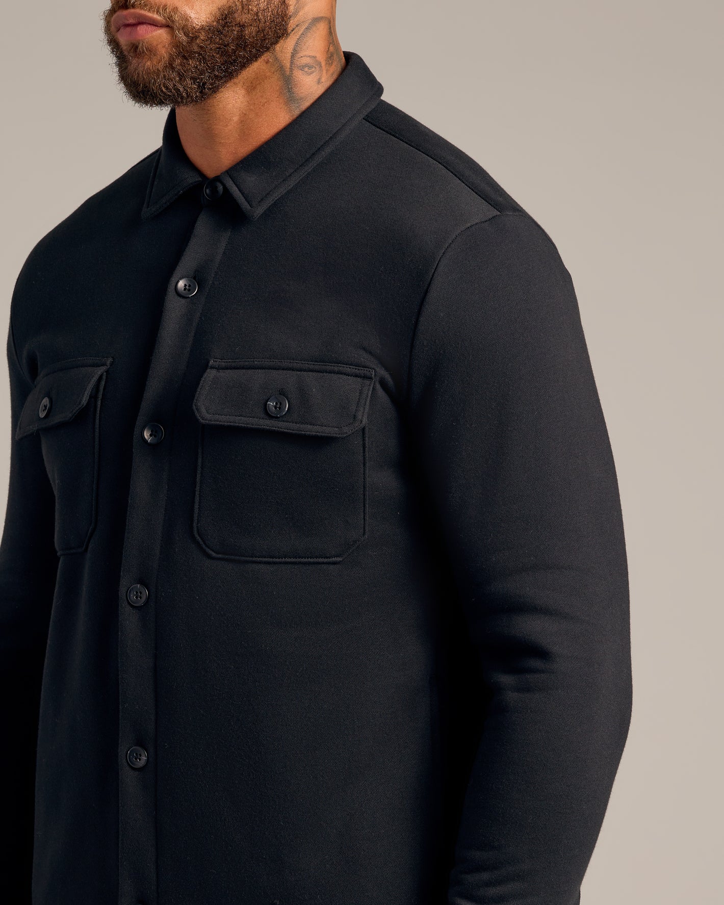 Black Fleece Shirt Jacket with buttoned chest pockets and neck tattoo visible.