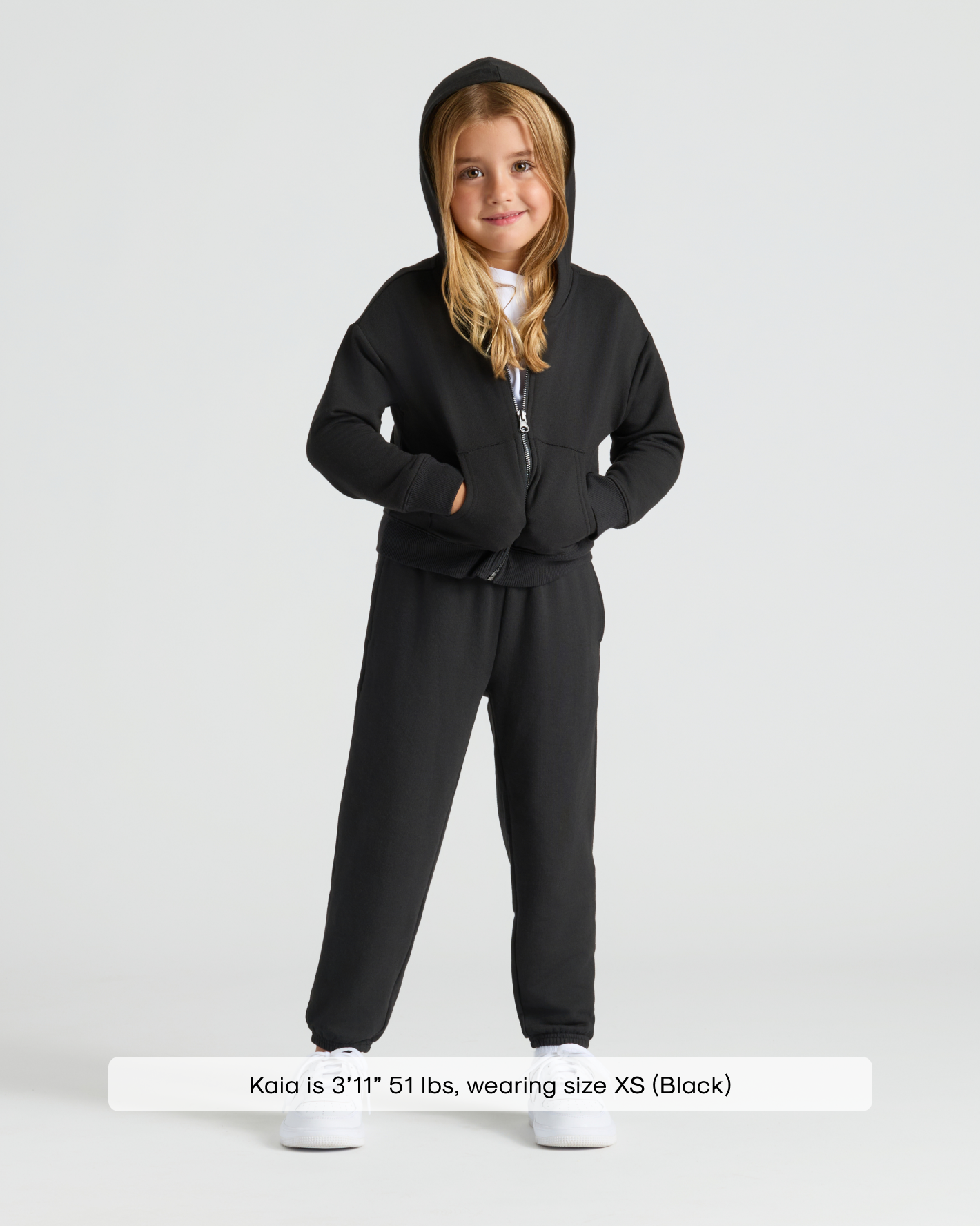 Girl modeling Girls Black Cropped Zip Hoodie with matching joggers.