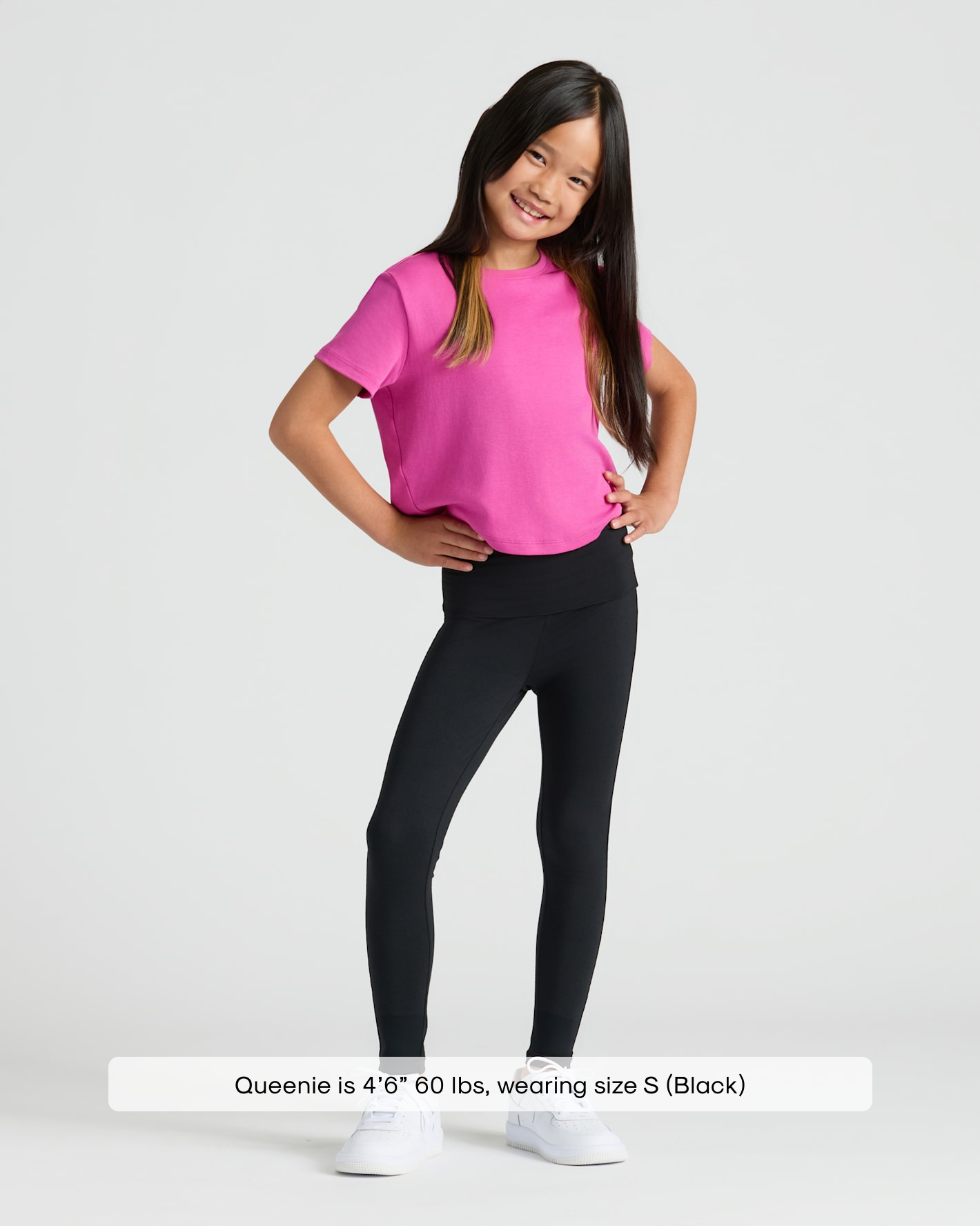Girl in Girls Black Foldover Leggings, smiling confidently with hands on hips.
