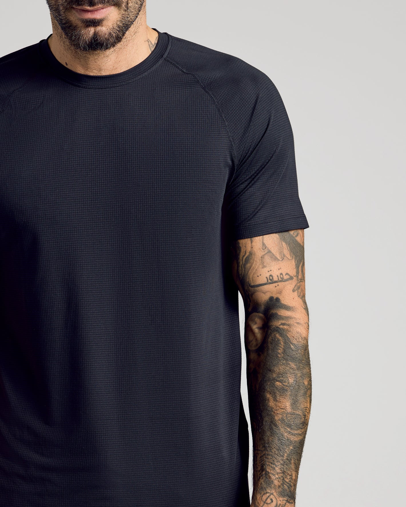 Black Active Mesh Crew 6-Pack on a tattooed arm, showcasing texture.