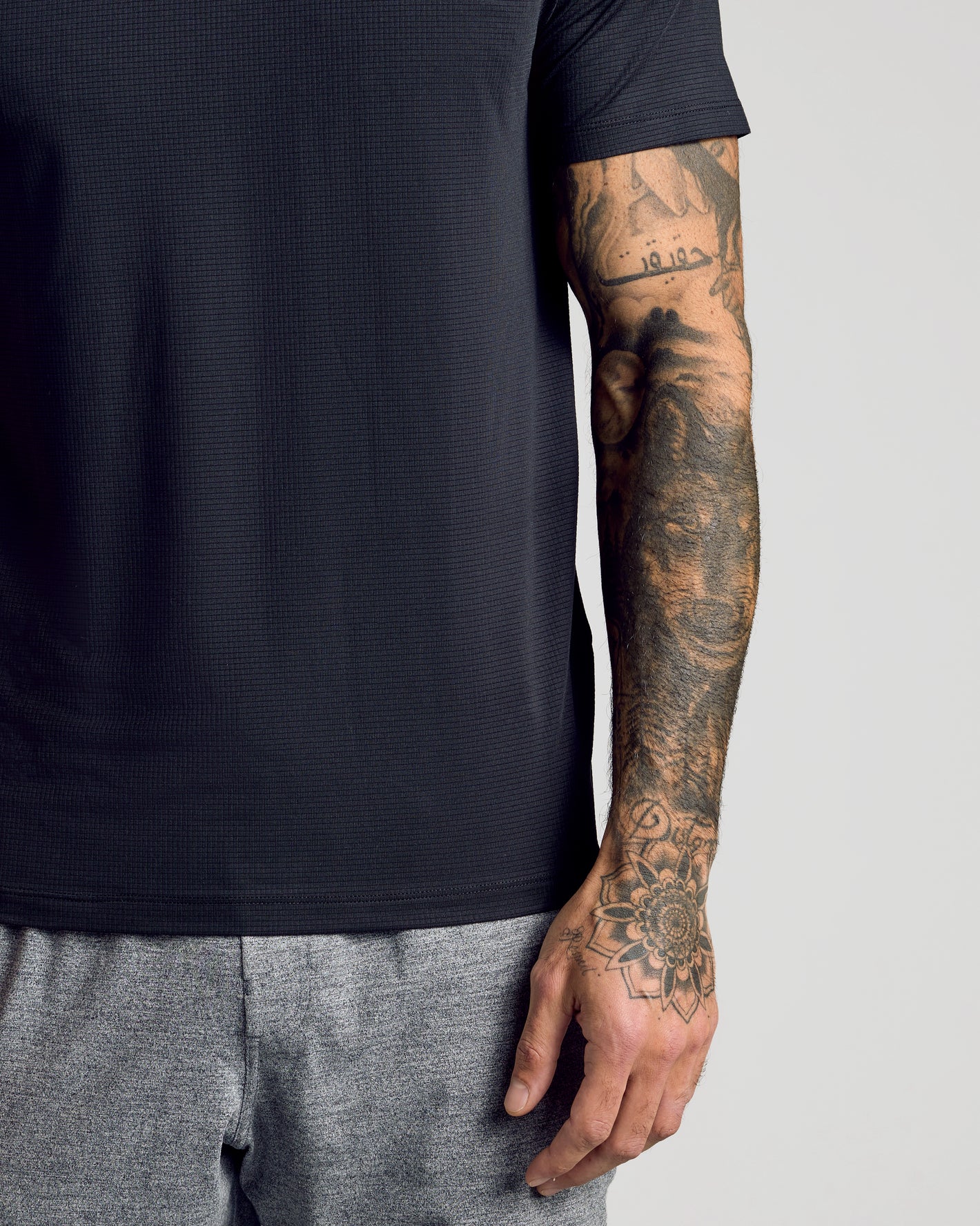 Black Active Mesh Crew 6-Pack on tattooed arm, showcasing breathable fabric.