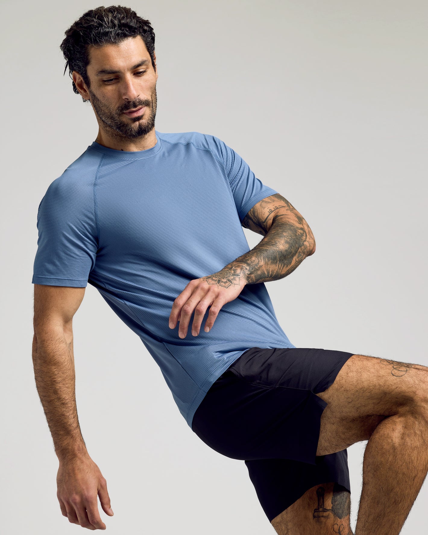 Man wearing Fiord Active Mesh Crew, balancing mid-stretch.