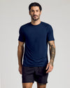 Man in navy Active Mesh Crew Tee and black shorts.