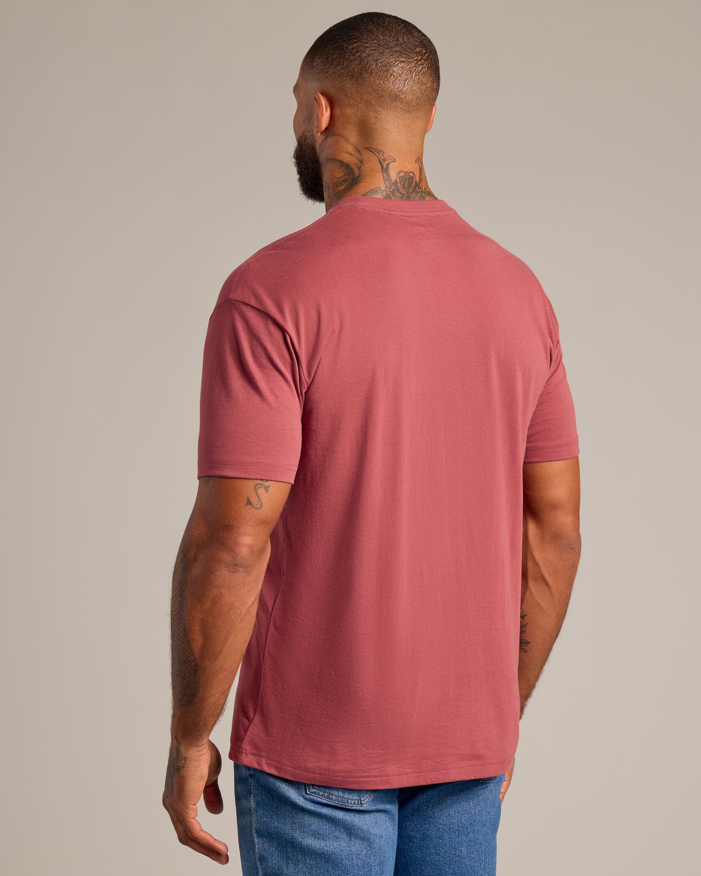 Man wearing Rustic Apple Short Sleeve Crew Neck T-shirt, showcasing tattoos.