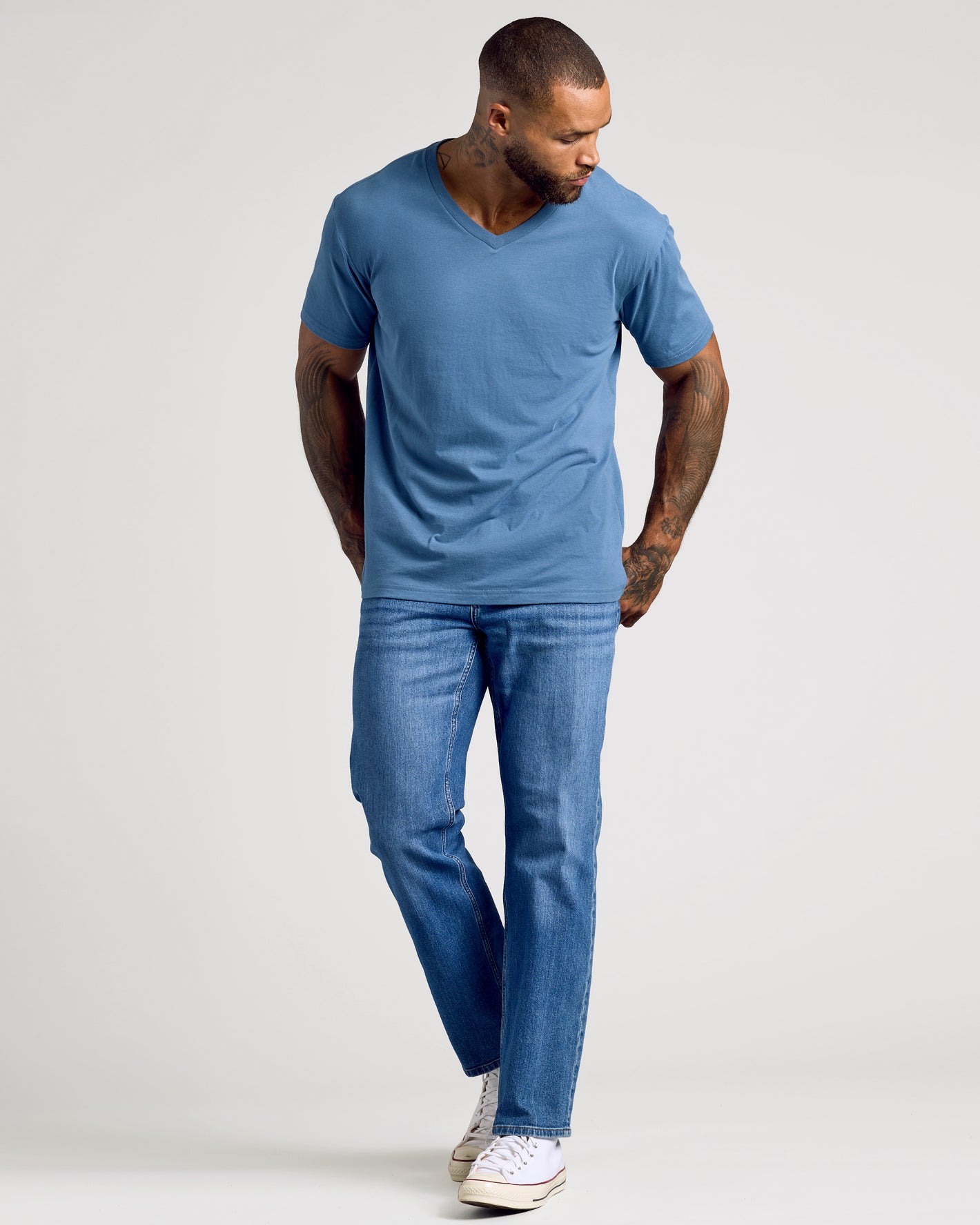 Fiord Classic V-Neck on tattooed model with jeans and sneakers.