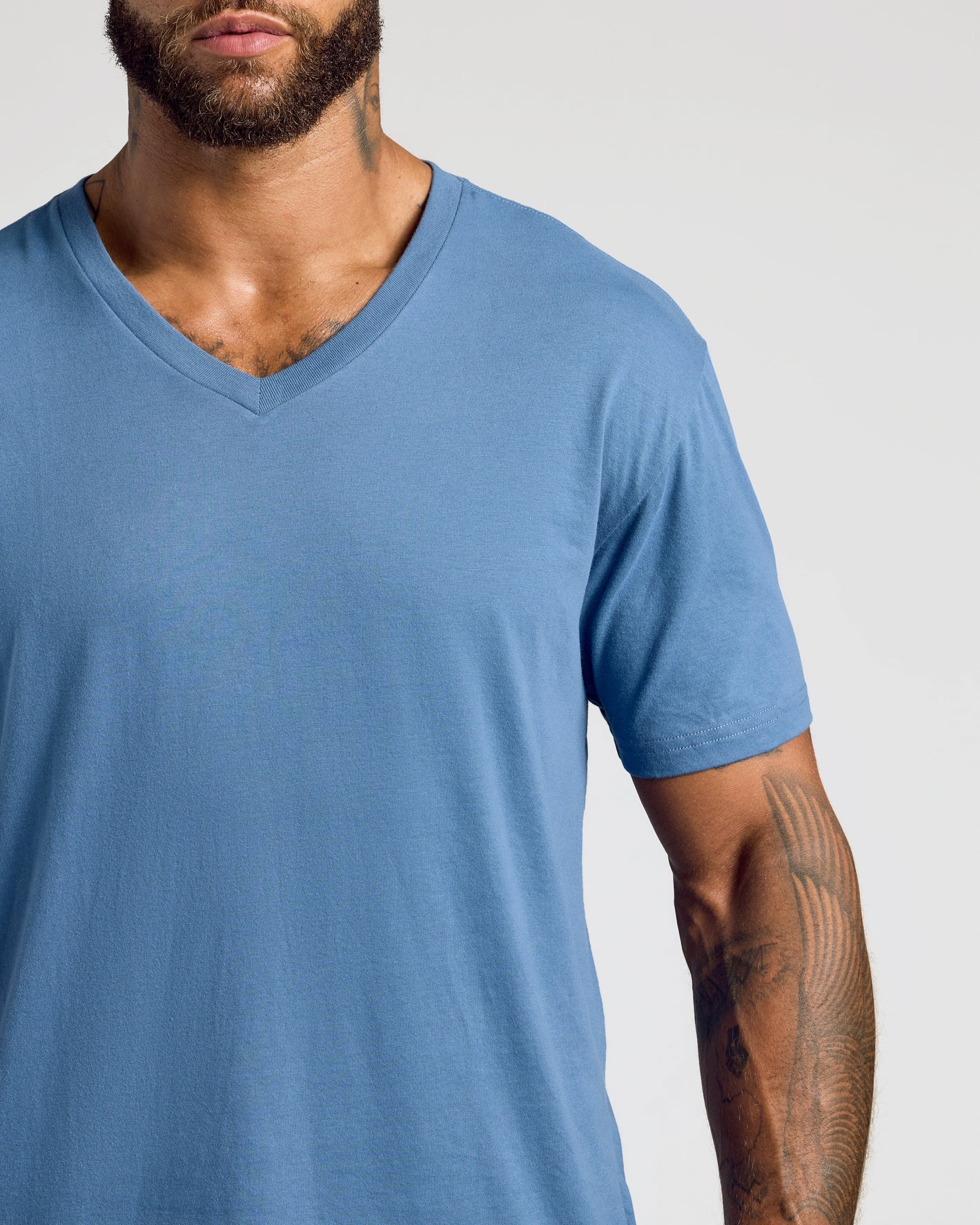 Fiord Classic V-Neck on bearded man, showcasing fit and tattooed forearm.