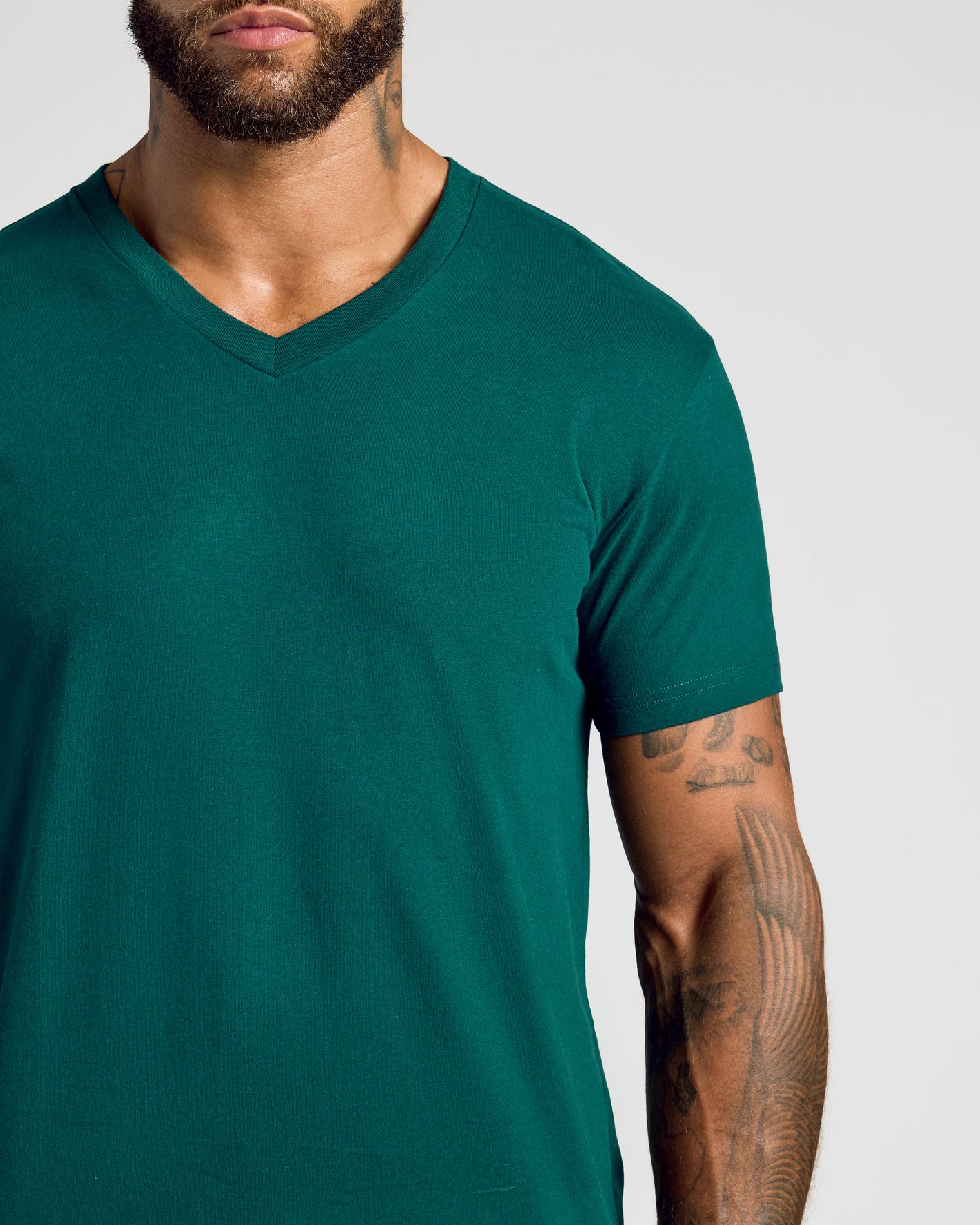 Viridian Classic V-Neck on bearded man with tattooed arm.