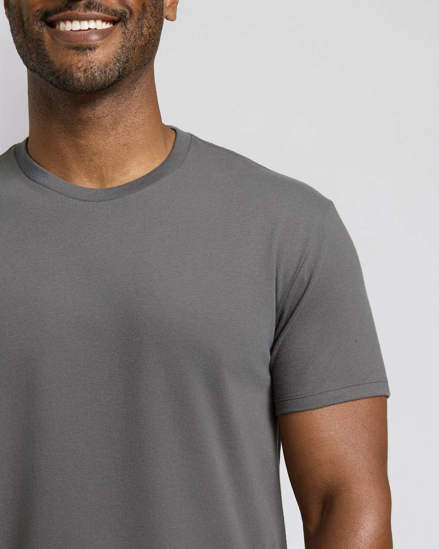 Man wearing a gray t-shirt against a plain background