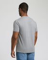 Man wearing a gray t-shirt and blue jeans on a plain background
