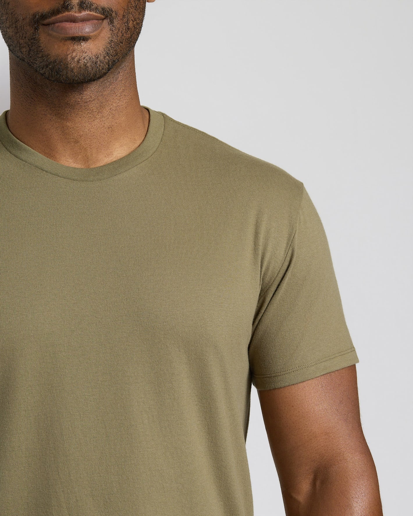 Man wearing a green t-shirt against a neutral background