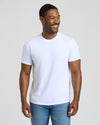 Man wearing a plain white t-shirt and blue jeans against a light background