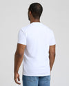 Man wearing a plain white t-shirt and blue jeans against a light background