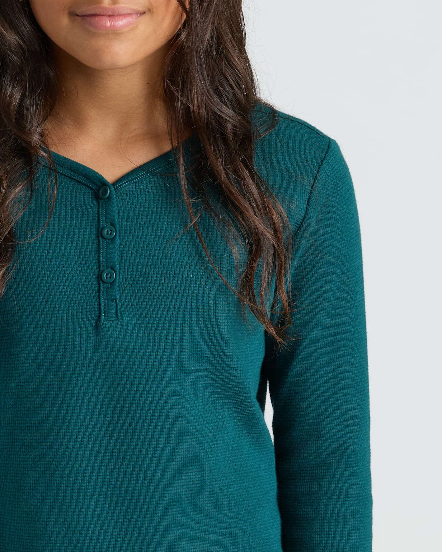 Girls Deep Emerald Waffle Henley on model, showcasing textured, cozy fabric.