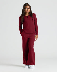 True ClassicGirl in Girls Long Sleeve Boxy Waffle Henley, burgundy set, smiling.