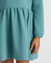 Child wearing Girls Long Sleeve Fleece Dress with tiered waist and pocket.