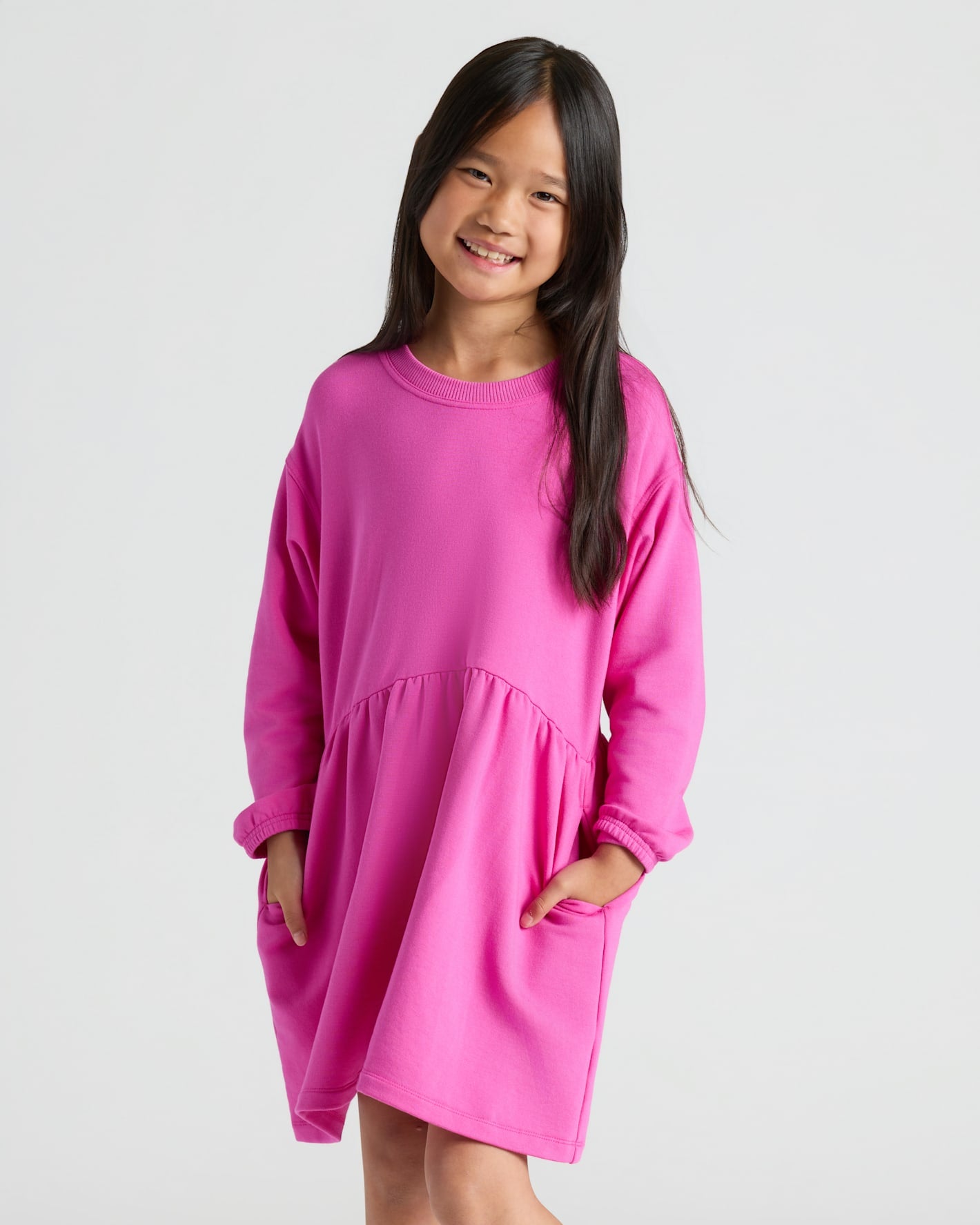 Girl in Girls Electric Fuchsia Long Sleeve Fleece Dress, smiling.