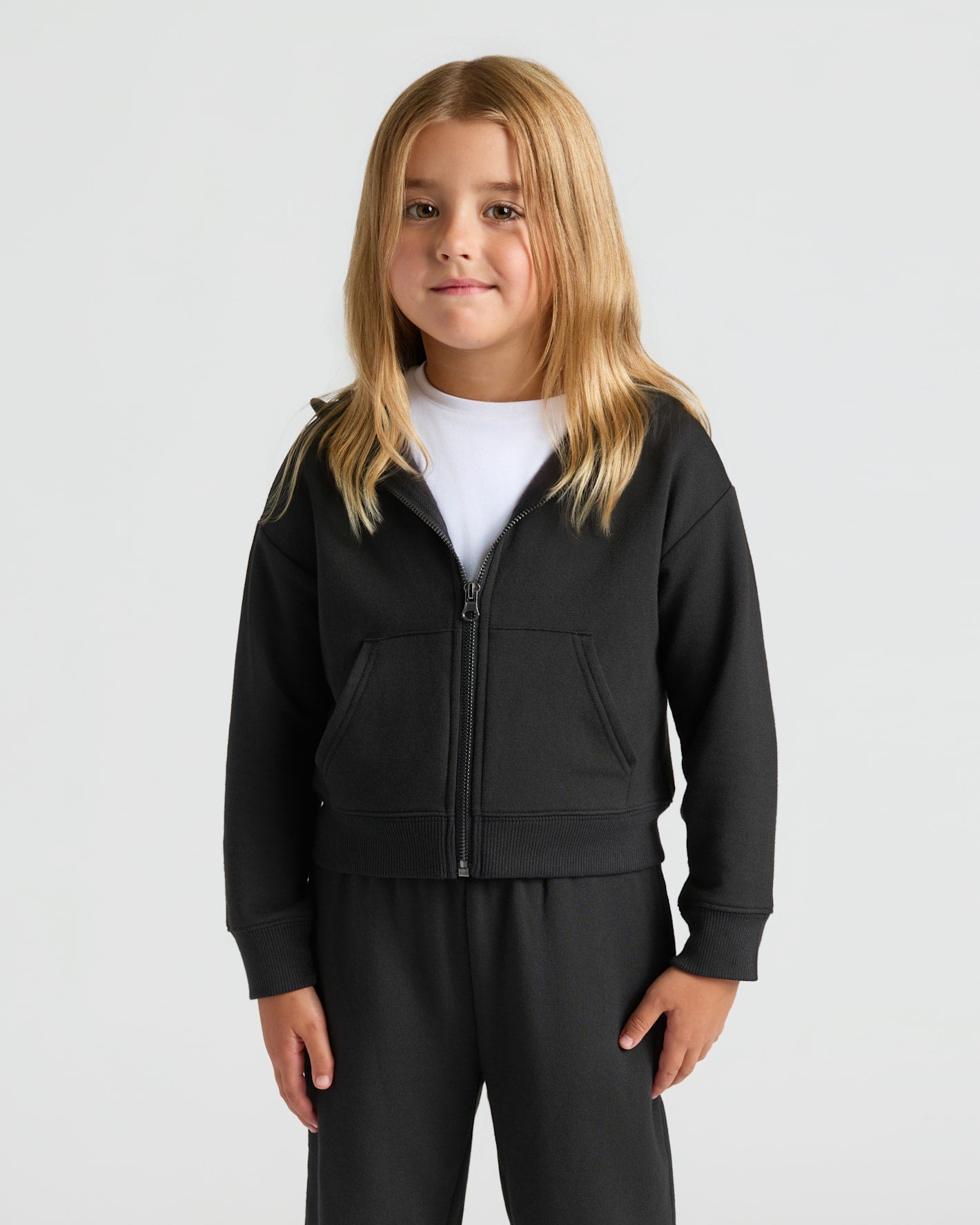 Girls Black Cropped Zip Hoodie & Relaxed Joggers worn by a young child.
