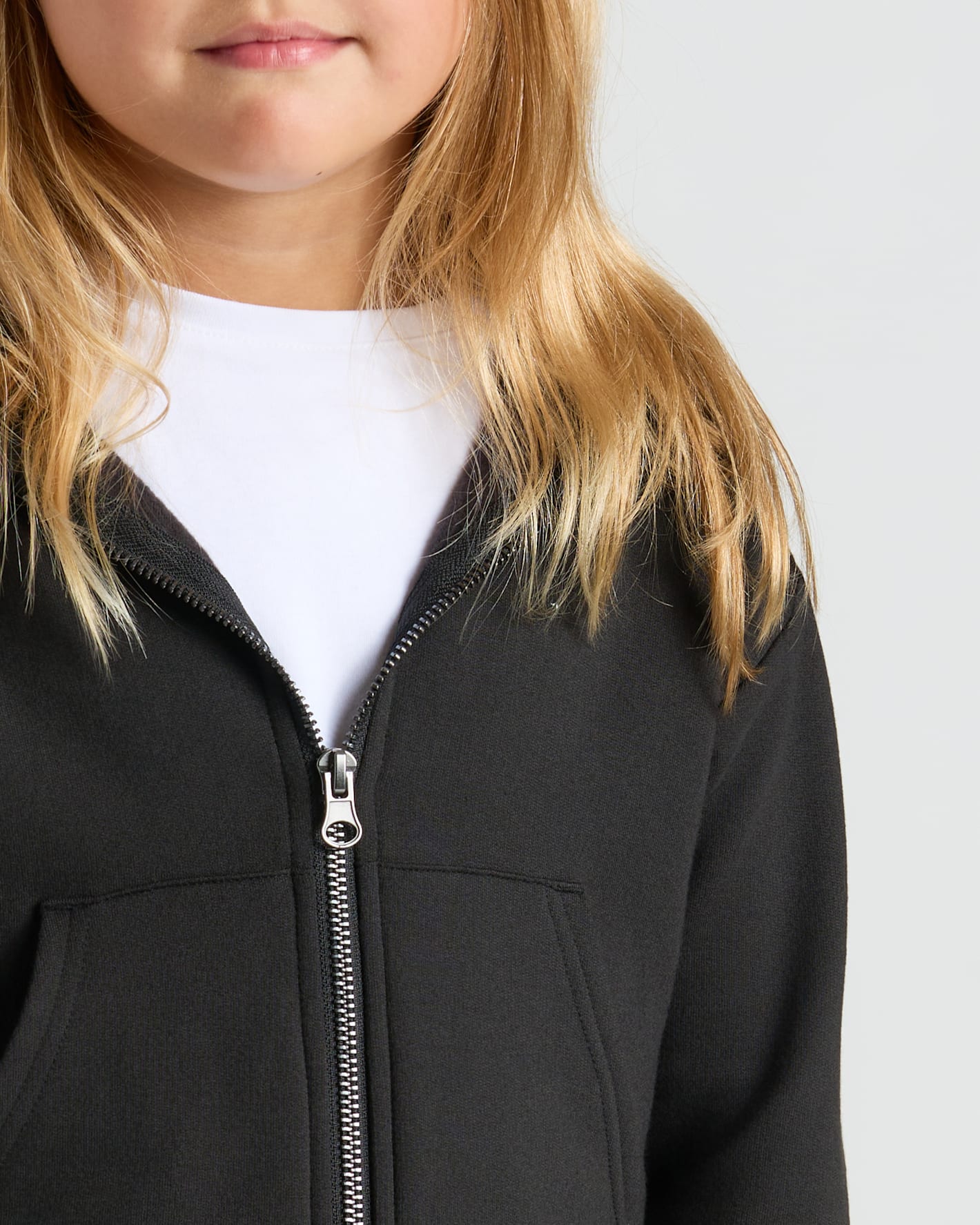 Young person wearing Girls Black Cropped Zip Hoodie & Relaxed Joggers.