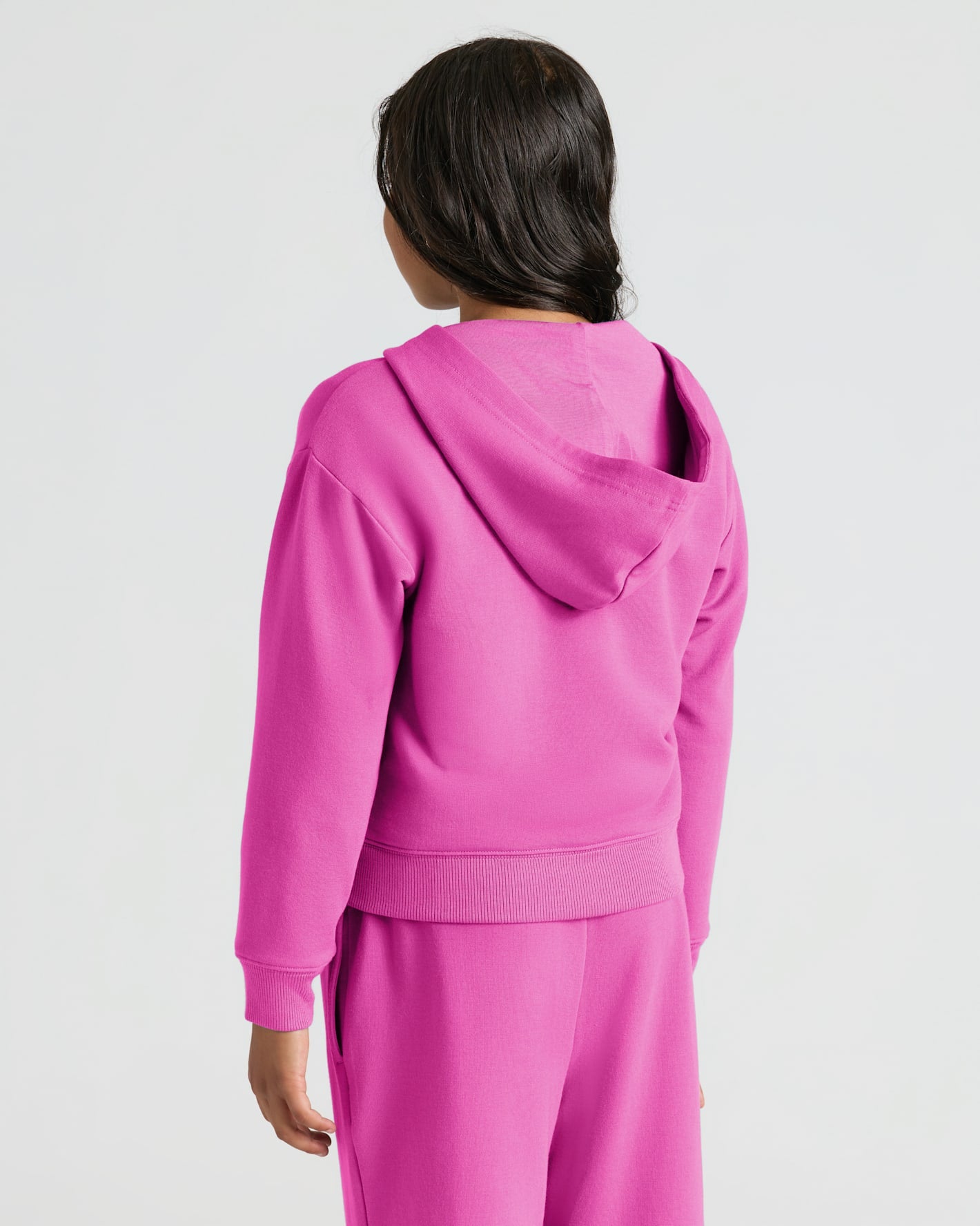 Person in Girls Electric Fuchsia Cropped Zip Hoodie & Relaxed Joggers.