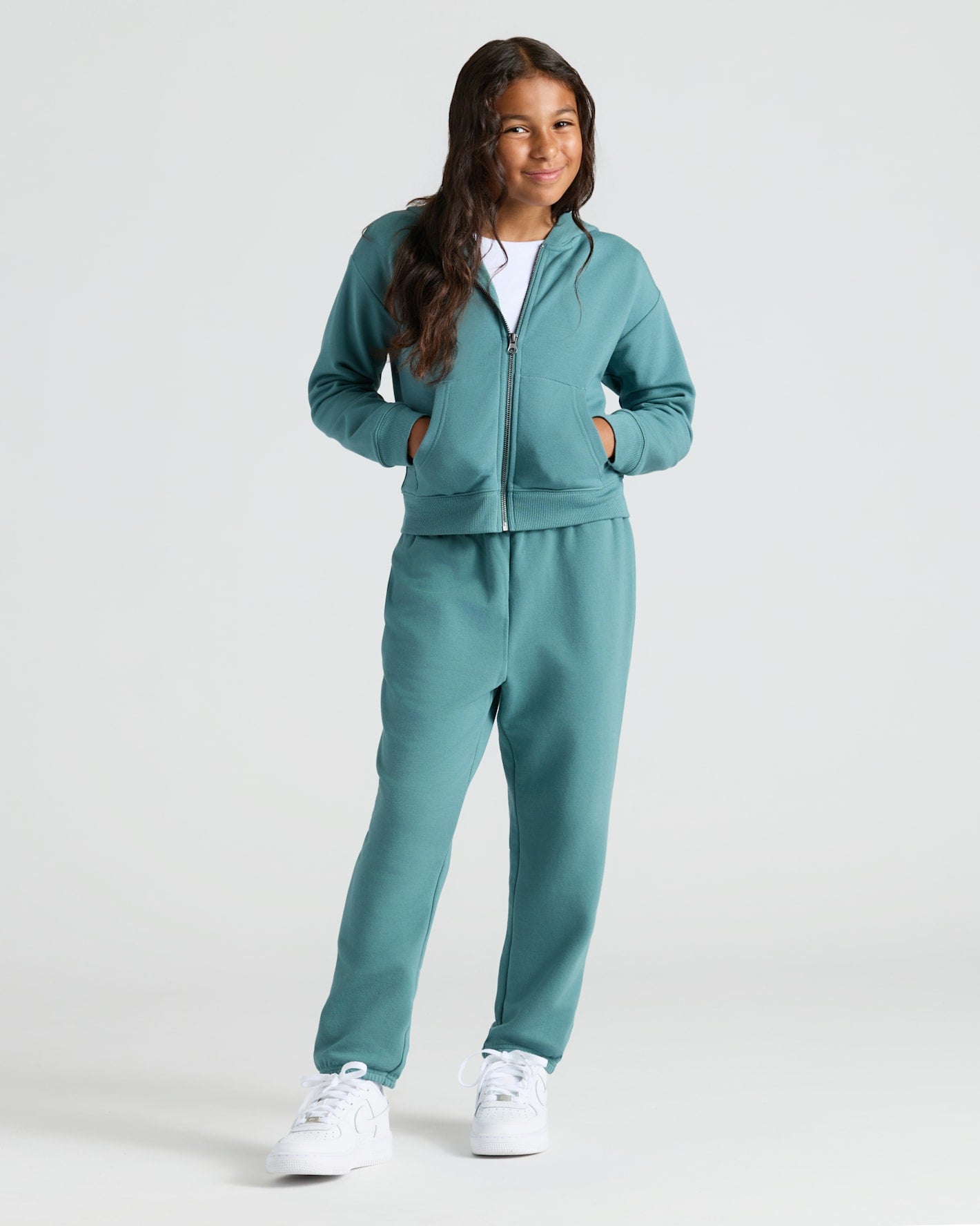 Girl in teal hoodie and joggers, showcasing Girls Black & Stormcloud Relaxed Joggers 2-Pack.