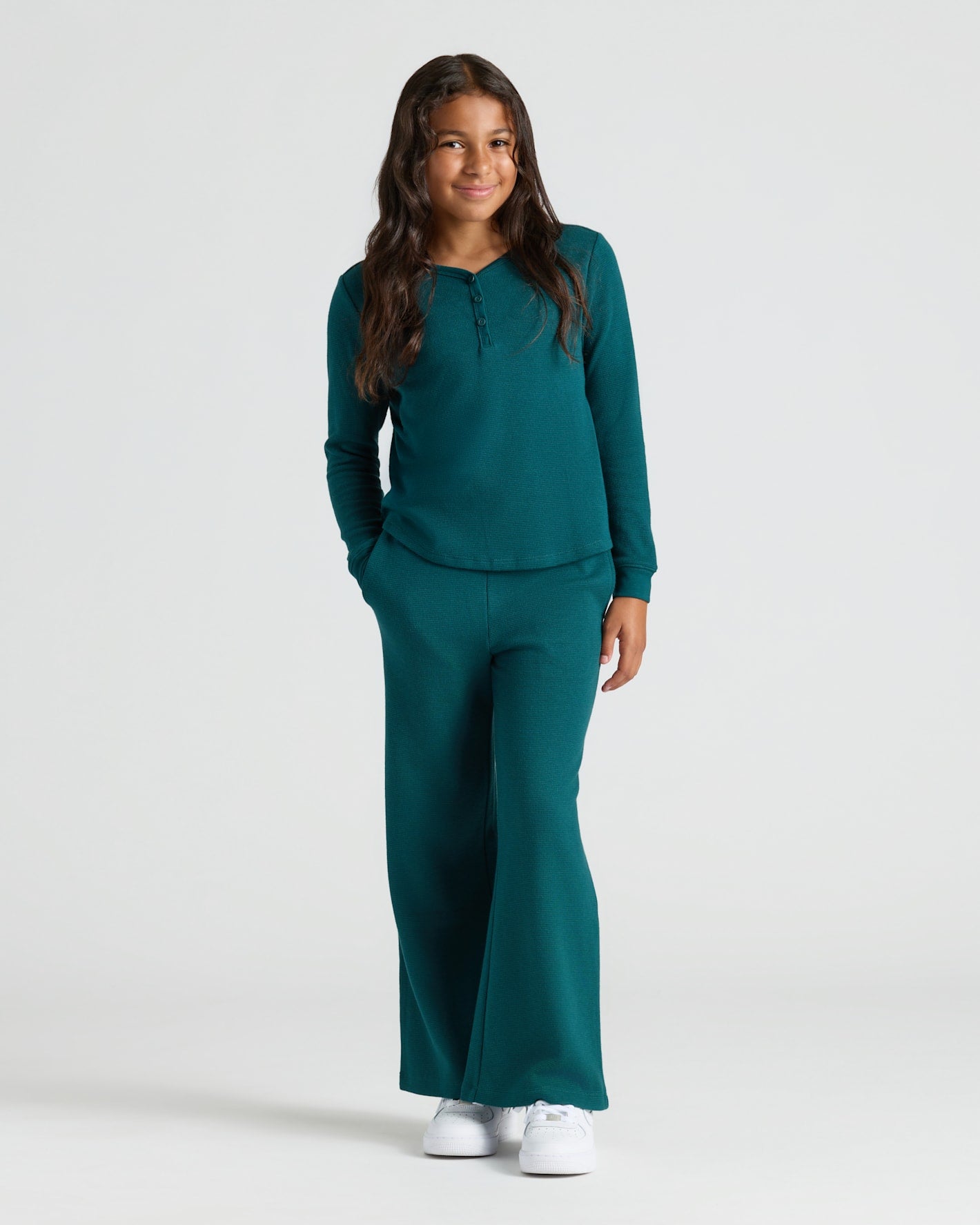 Girl in teal Girls Waffle Wide Leg Pants set, smiling, hands in pockets.