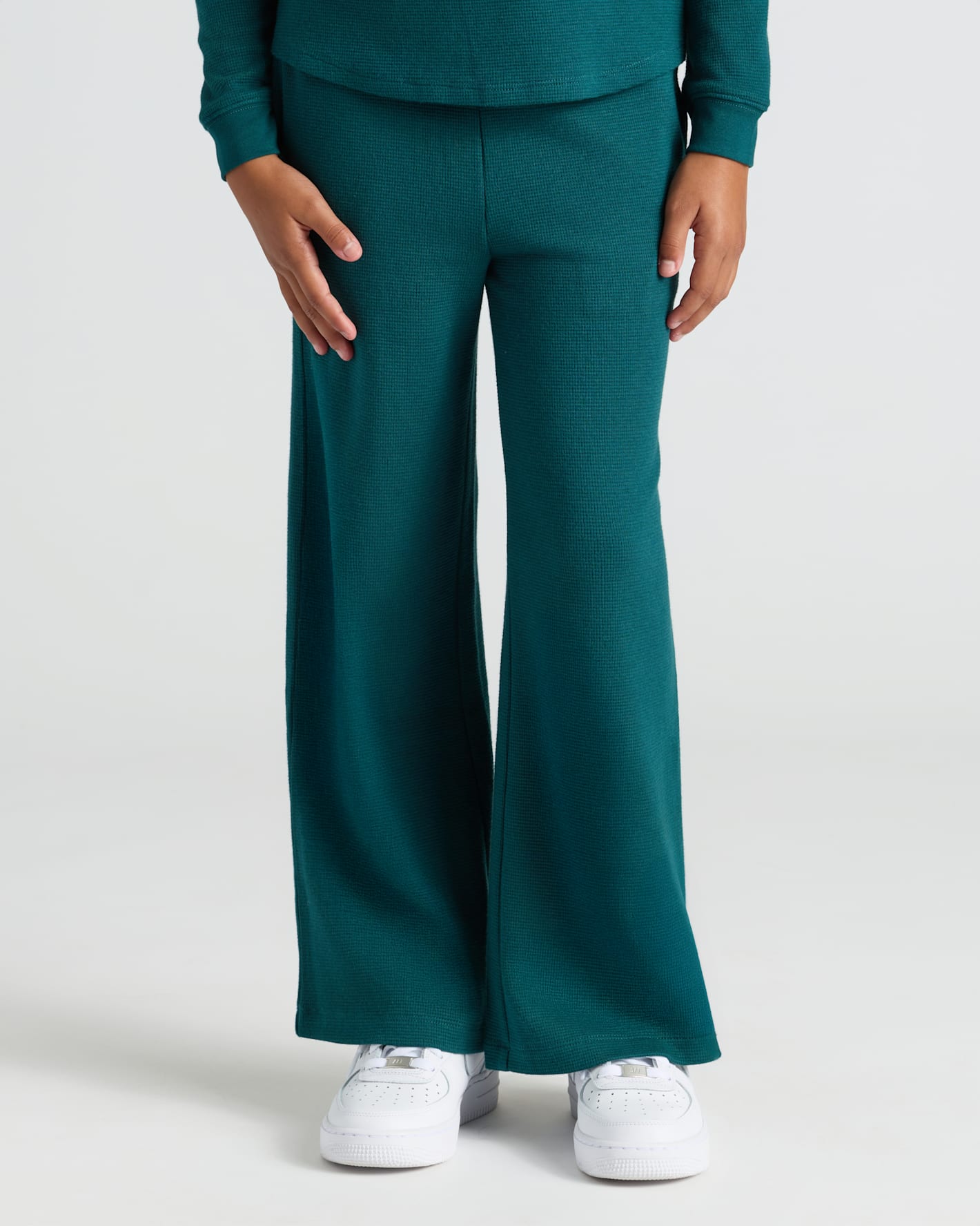 Child wearing Girls Deep Emerald Waffle Wide Leg Pants with white sneakers.