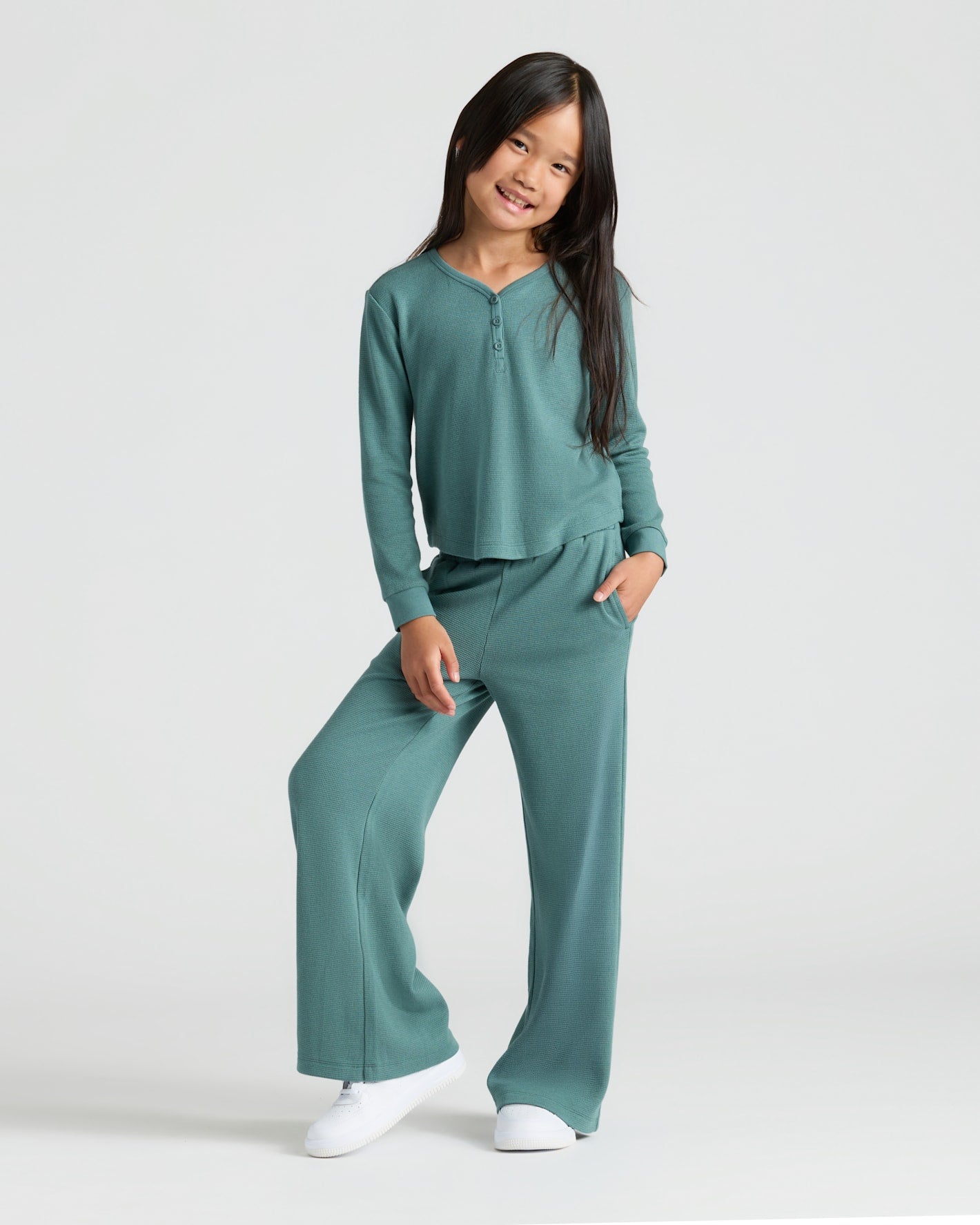 Girl in teal outfit wearing Girls Waffle Wide Leg Pants 3-Pack.