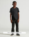 Boy in Boys' Black Classic Curved Hem Crew Neck, black pants, gray sneakers.