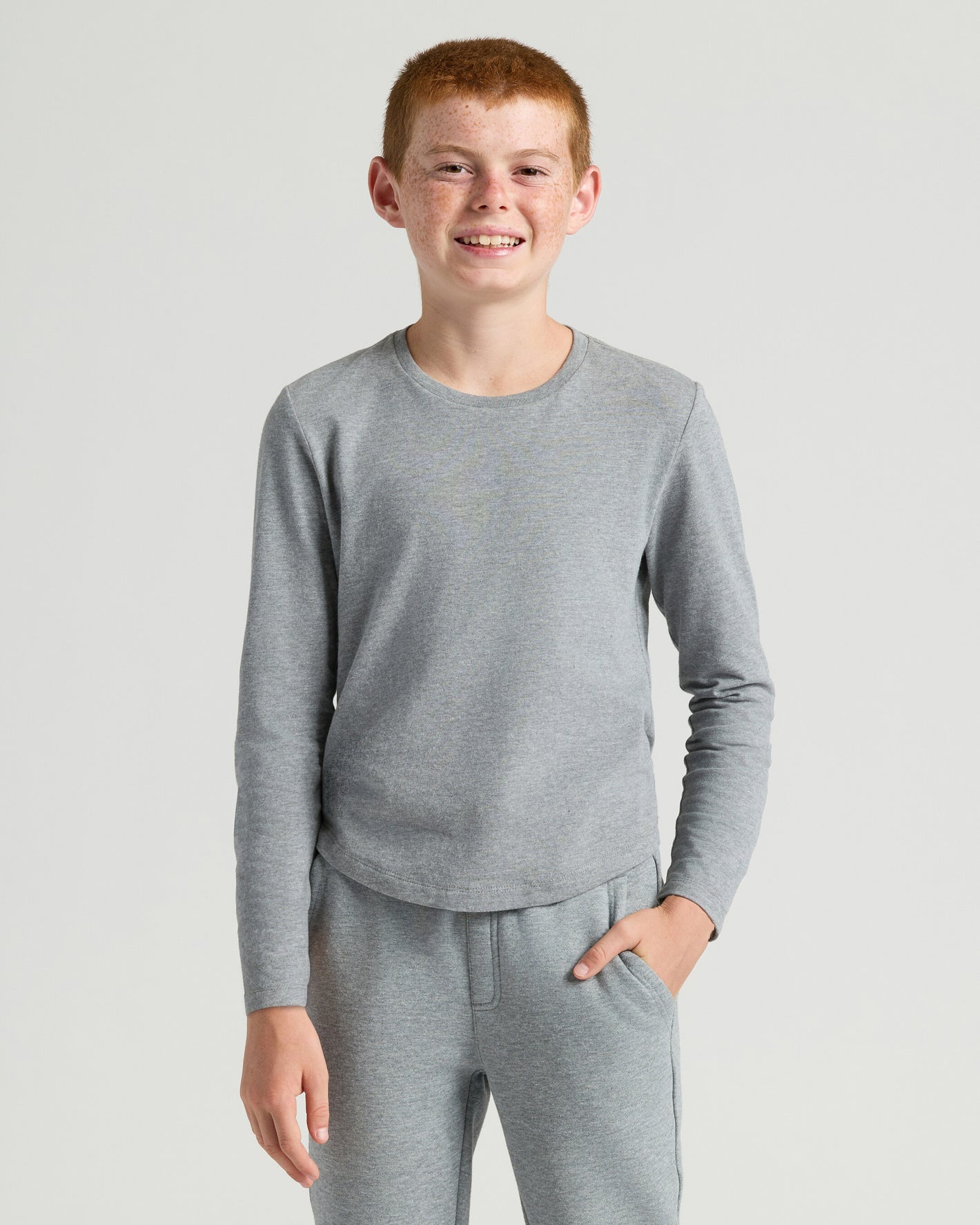 Boy in grey Boys' Classic Long Sleeve Curved Hem Crew Neck 3-Pack loungewear.